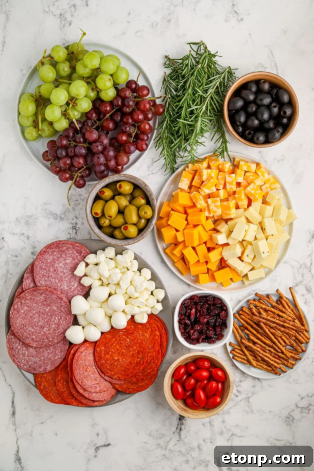 Ingredients for a Christmas charcuterie board laid out on a marble counter