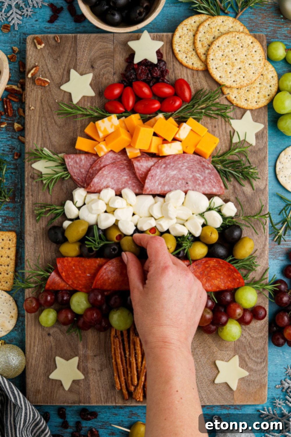 Picking food off the charcuterie board to eat
