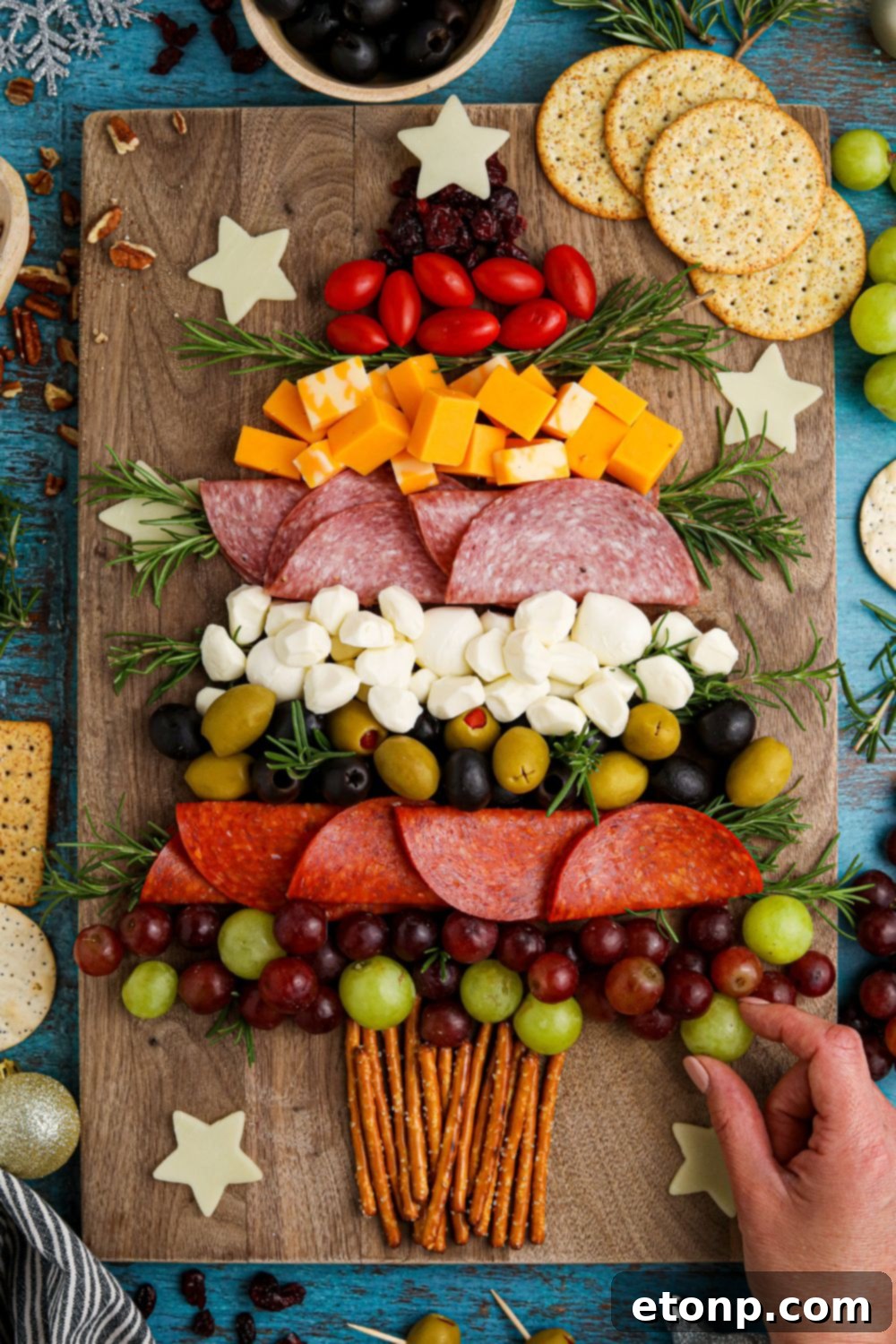 Grabbing a grape off a snacking board that is on a table