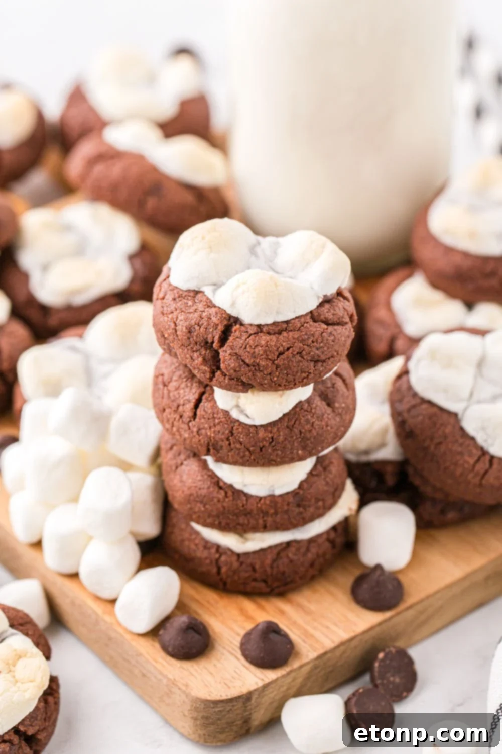 A beautiful arrangement of hot chocolate cookies on a table, with a glass of milk in the background.