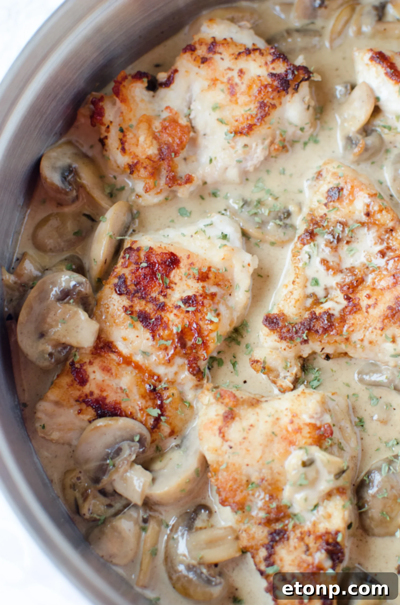Pouring dry white wine into a hot skillet with sauteed ingredients