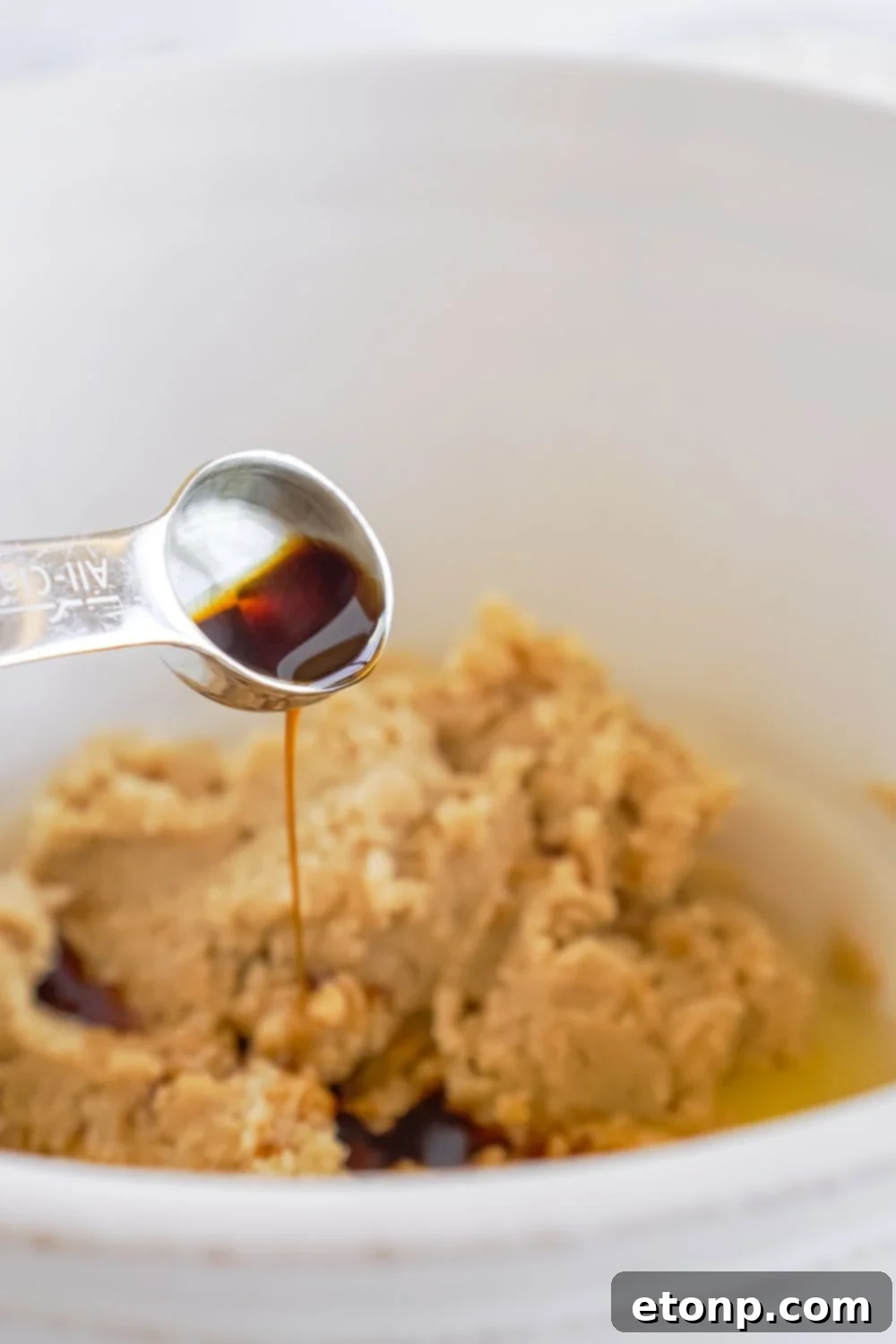vanilla being poured into a cookie dough batter