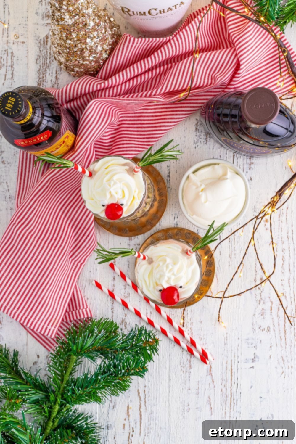 overhead view of milkshakes in glasses on table with christmas decor around it 
