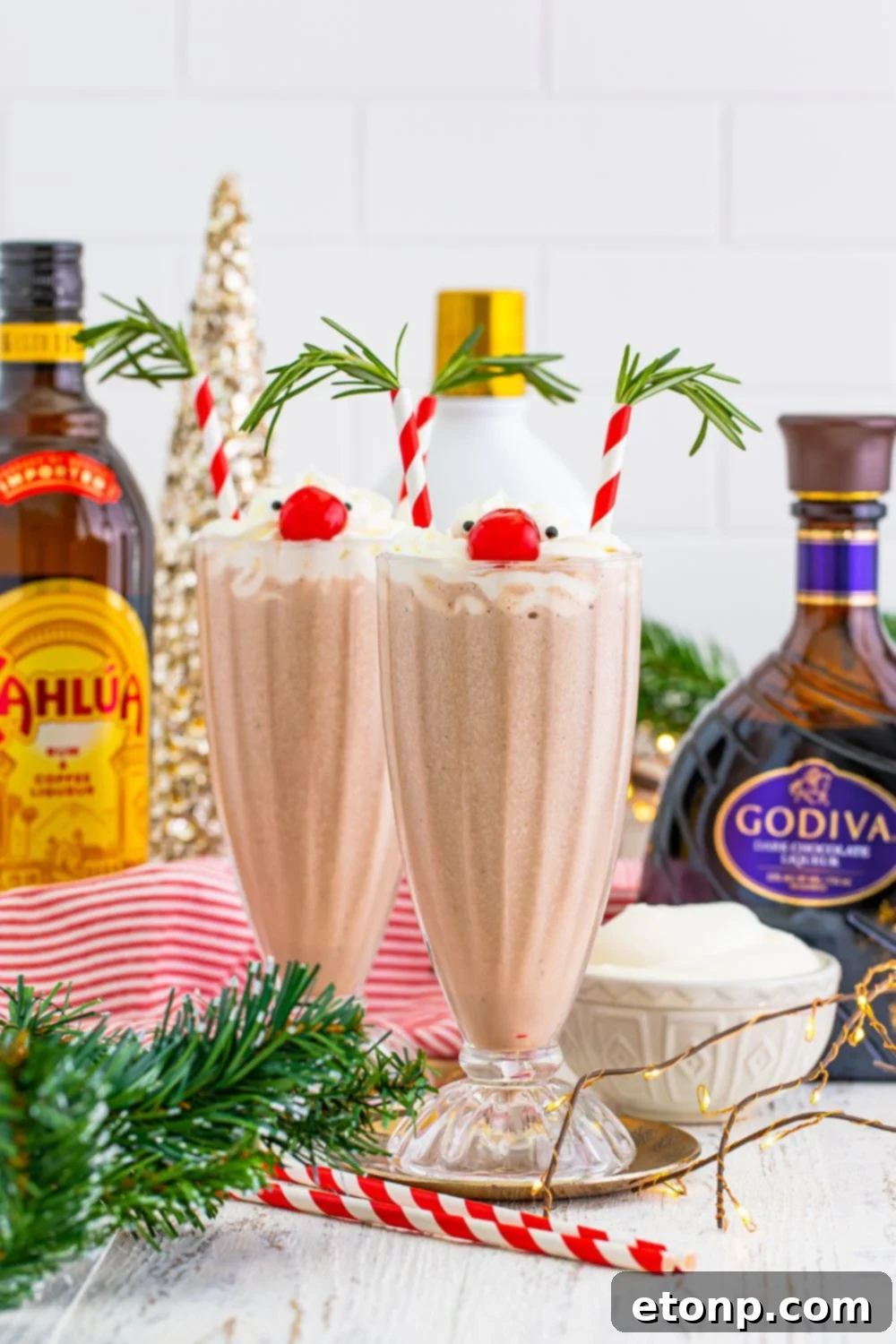 tipsy milkshakes with alcohol bottles behind them on table 