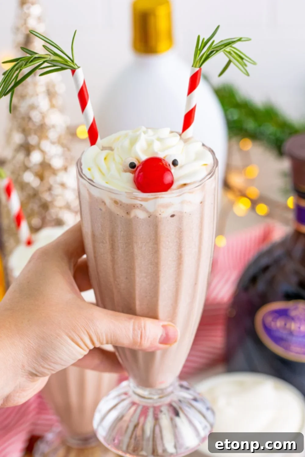 holding milkshake in hand above table