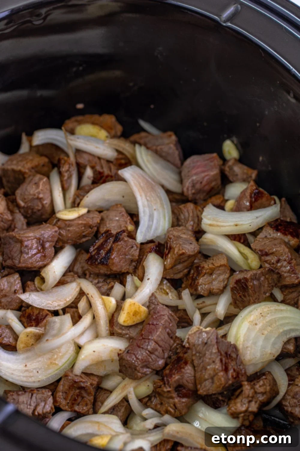 seared steak and veggies mixed up in a slow cooker 