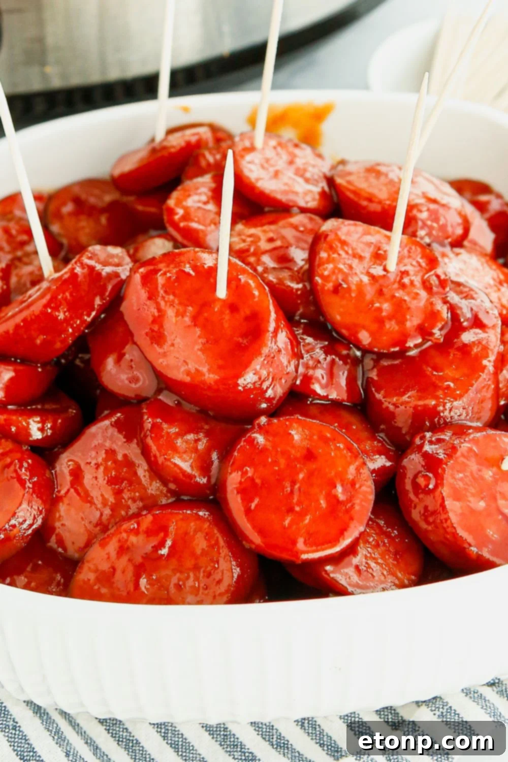 A bowl overflowing with Crockpot Kielbasa Bites, each speared with a toothpick for easy enjoyment, ready for guests.