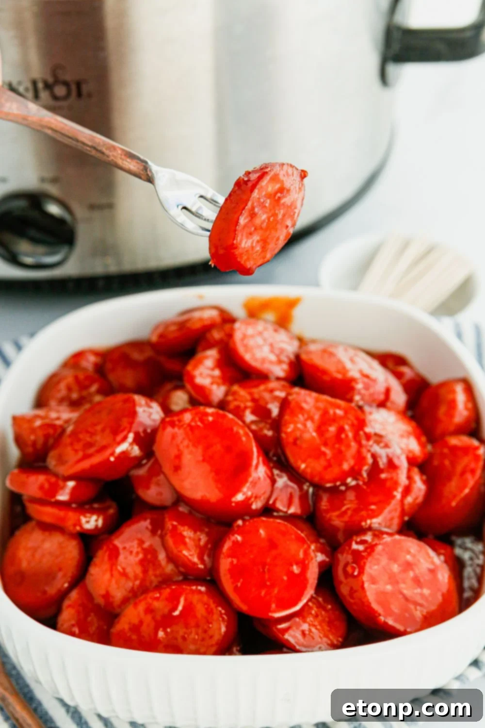 A single, delectable kielbasa bite expertly speared on a fork, ready to be enjoyed.