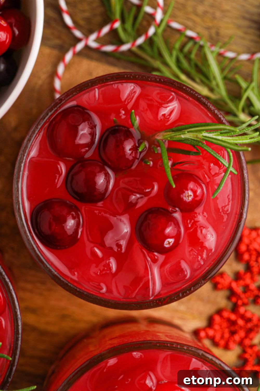 A festive glass of Mistletoe Punch, showcasing its rich red hue and holiday garnishes, ready for a toast.