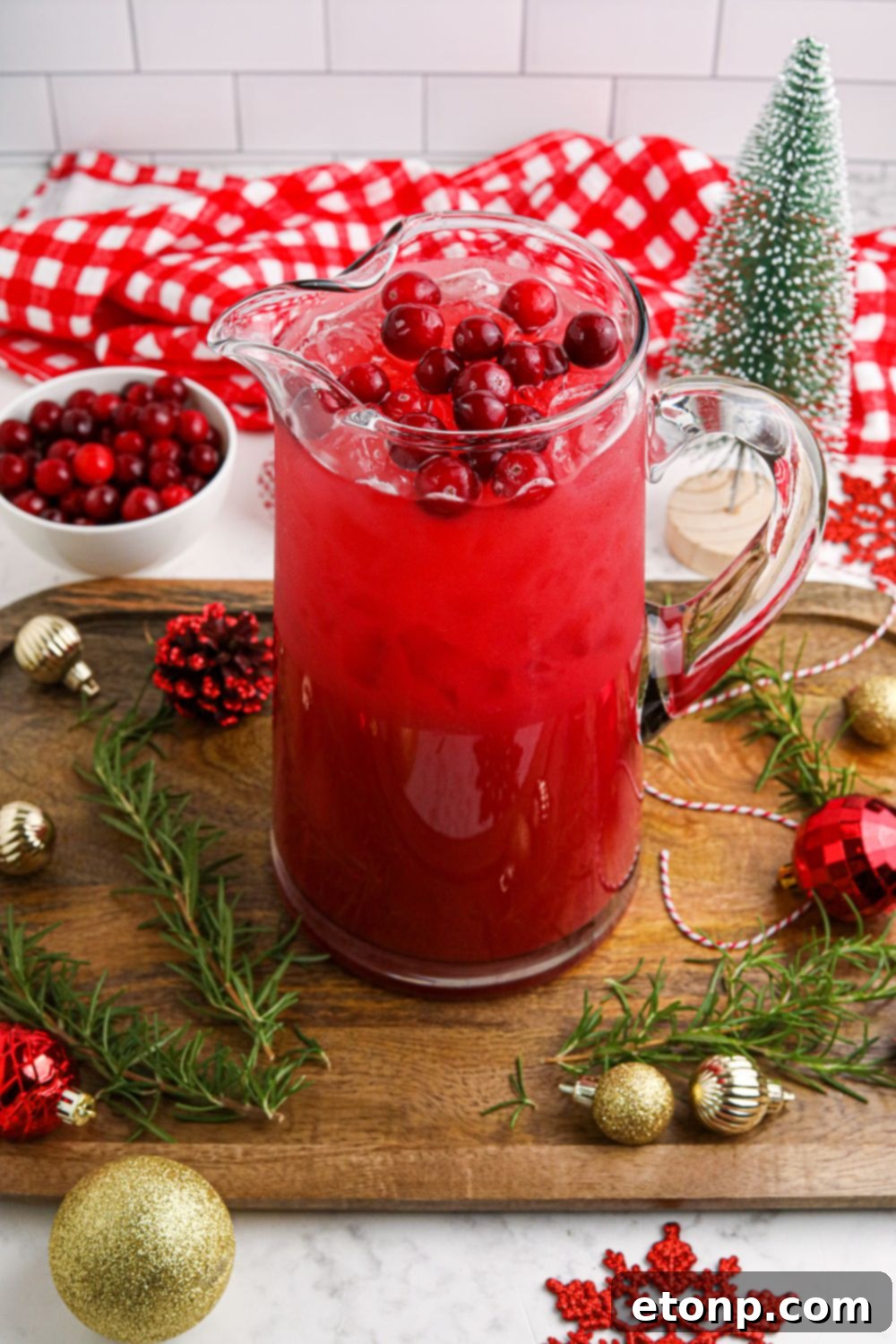 A Santa-themed punch in a large glass pitcher, sparkling with holiday cheer, ready for serving.