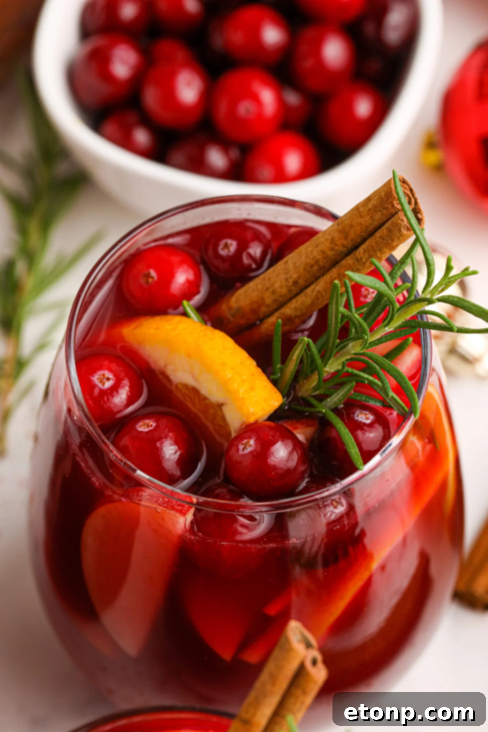Cranberry Apple Christmas Sangria with fresh cranberries and cinnamon sticks in a clear glass 