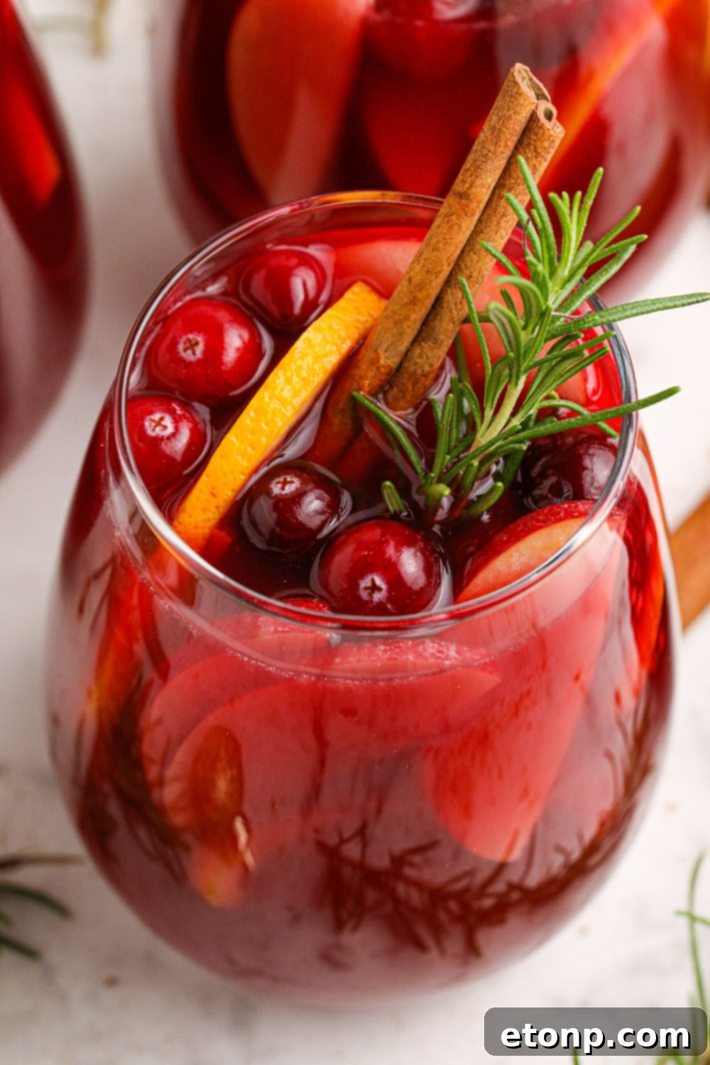 glasses of wine cocktails in it with cranberries and an orange slice in glasses