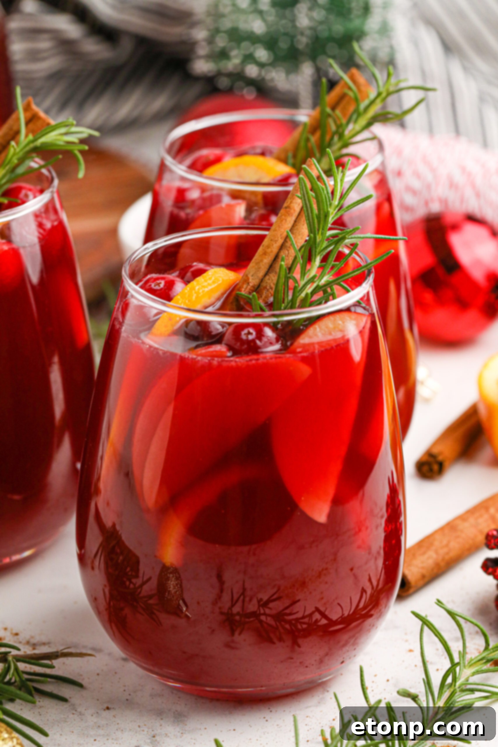 Cranberry Apple Christmas Sangria with fresh cranberries and cinnamon sticks in a clear glass 