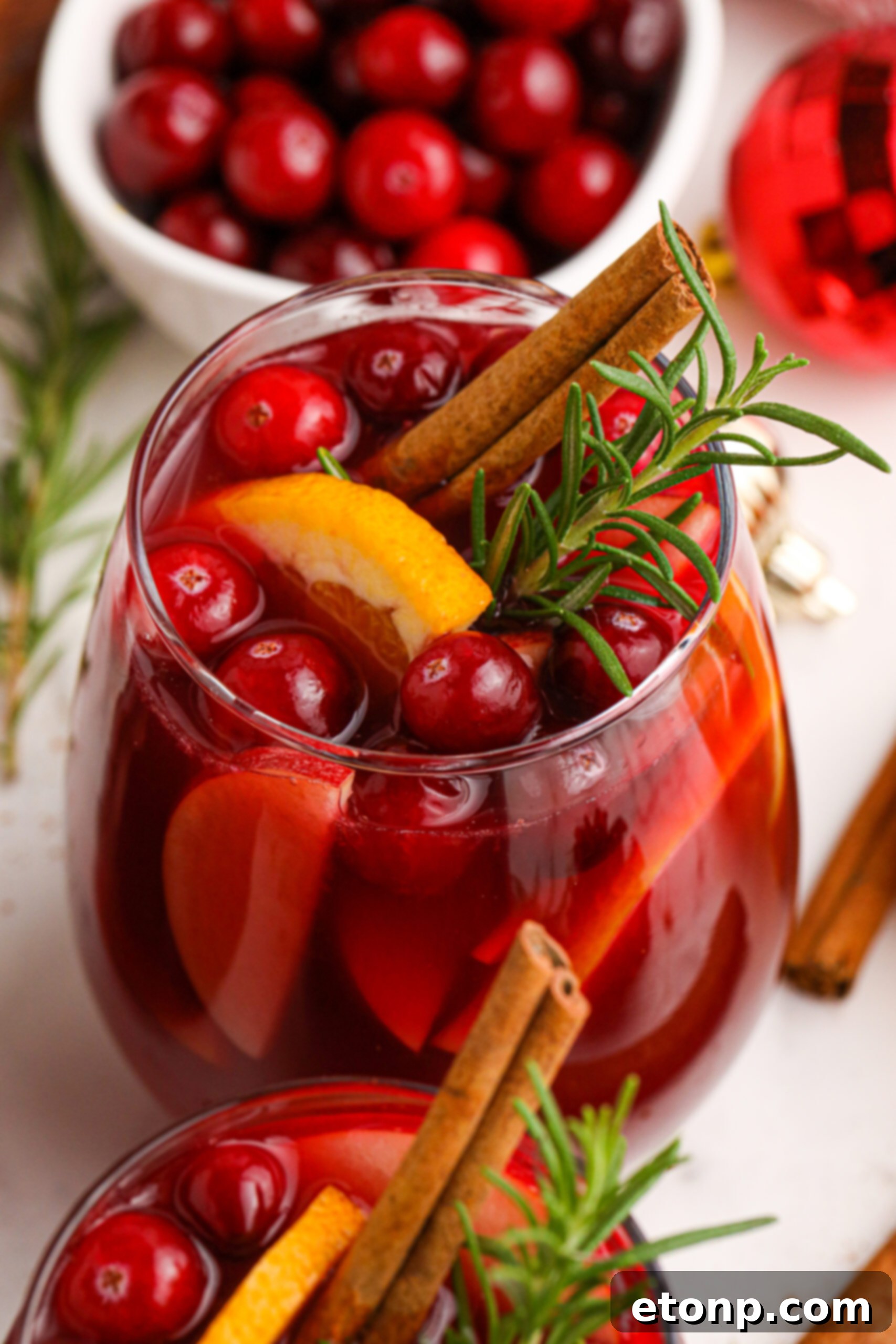 Cranberry Apple Christmas Sangria with fresh cranberries and cinnamon sticks in a clear glass 