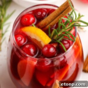Cranberry Apple Christmas Sangria in a glass with garnishes