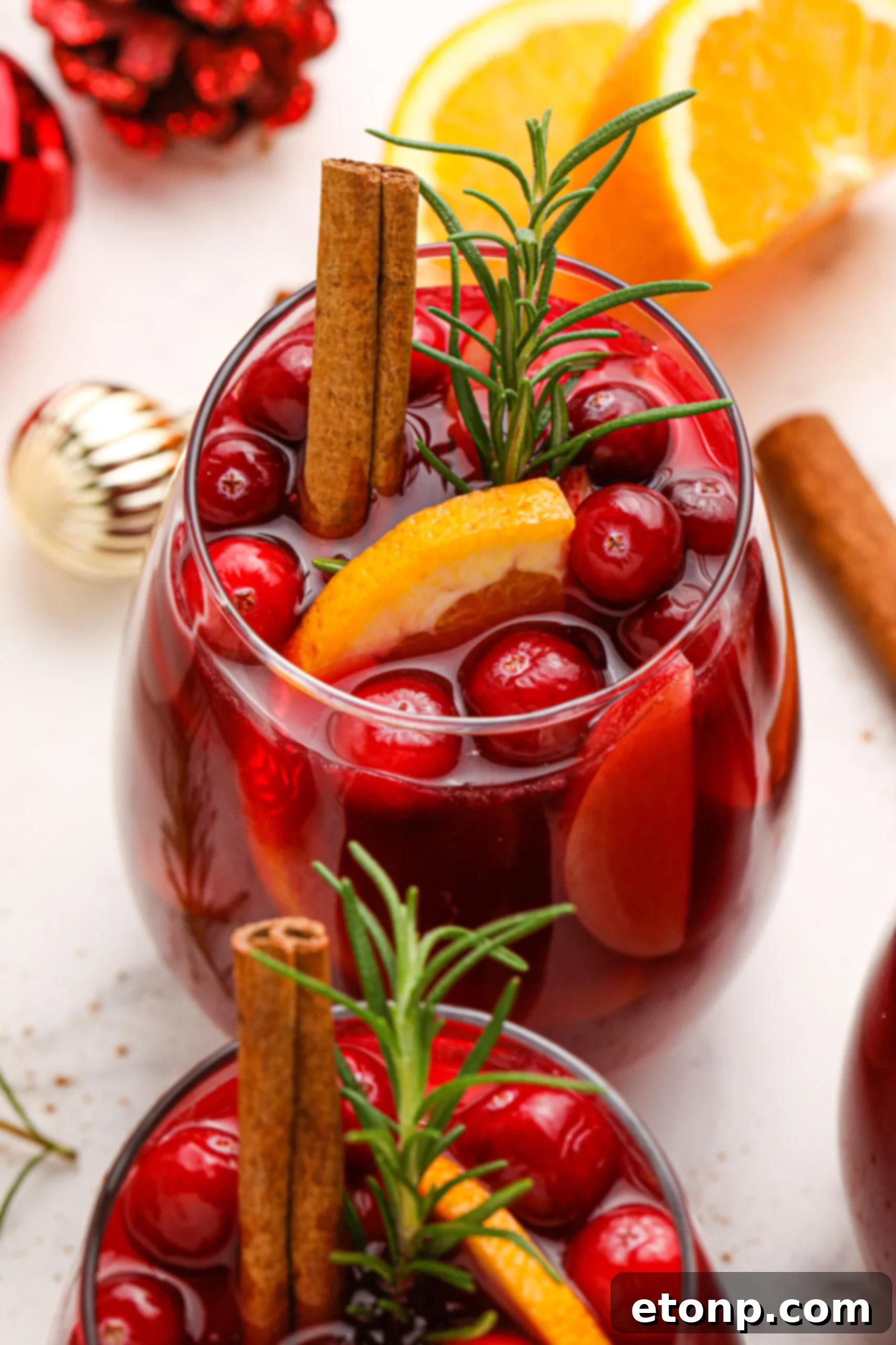 Cranberry Apple Christmas Sangria with fresh cranberries and cinnamon sticks in a clear glass 