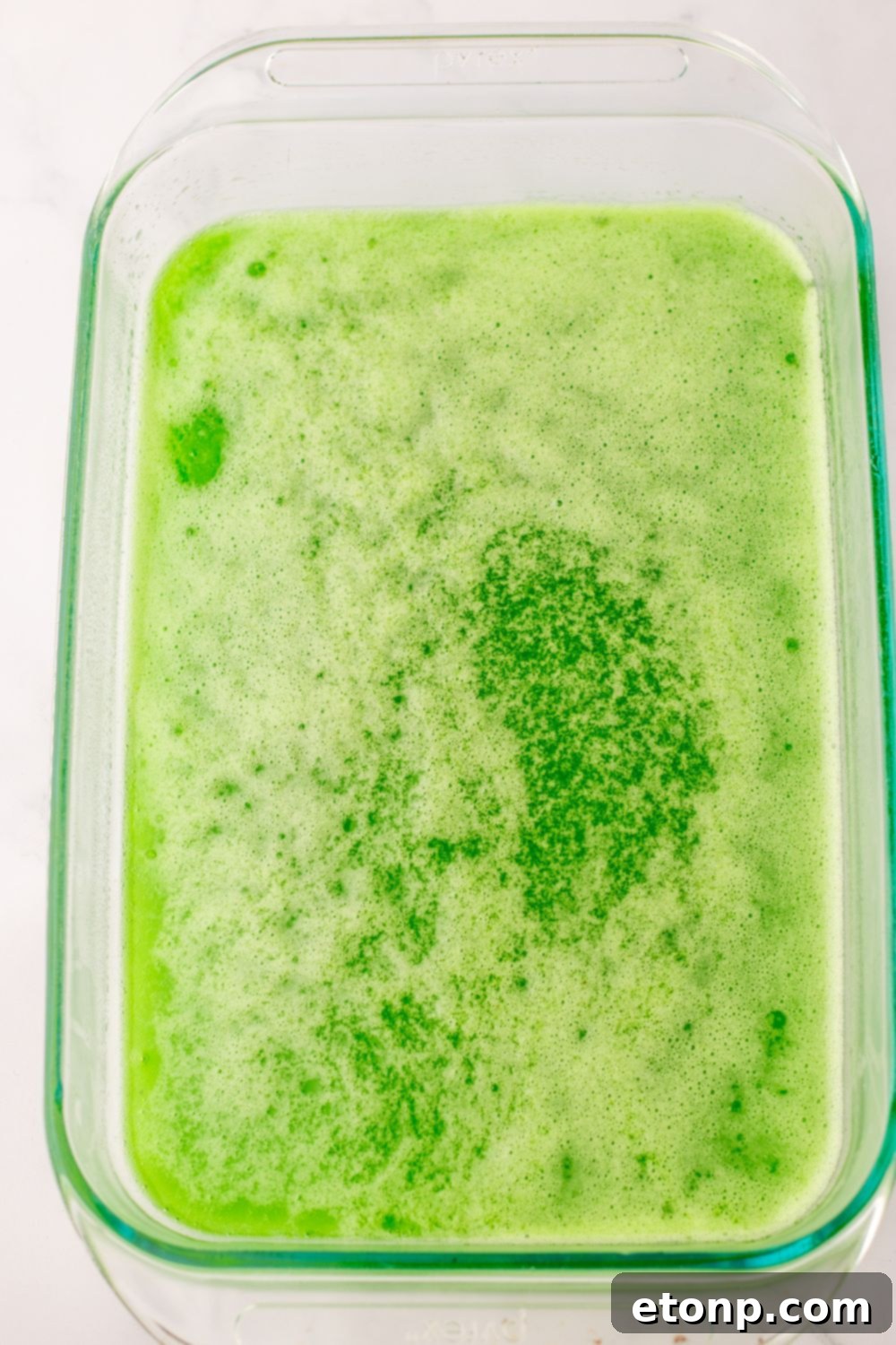 Holiday Gumdrop Gems 9 Green jello mixture being carefully poured into a prepared pan