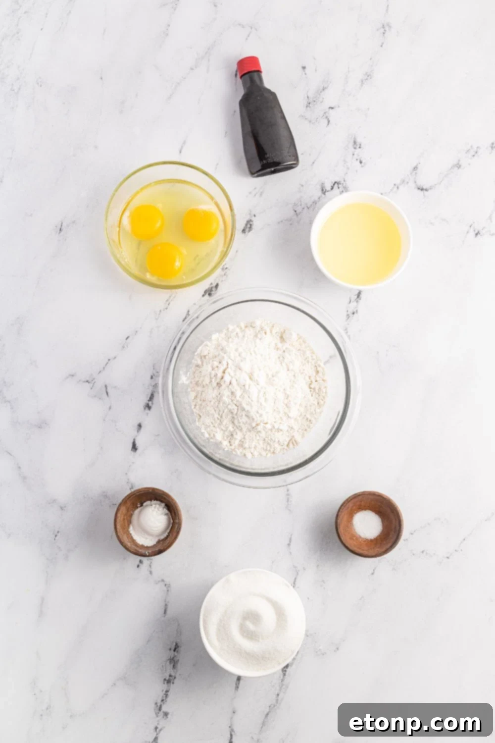 Pizzelles 6 ingredients to make Pizzelles cookies on a marble counter