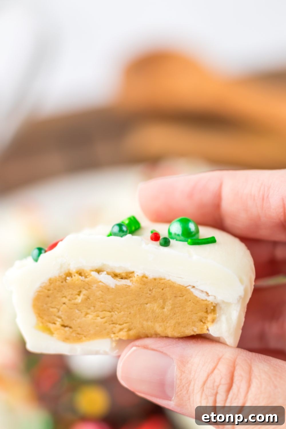 Peanut butter cup with white chocolate cut in half being held in hands
