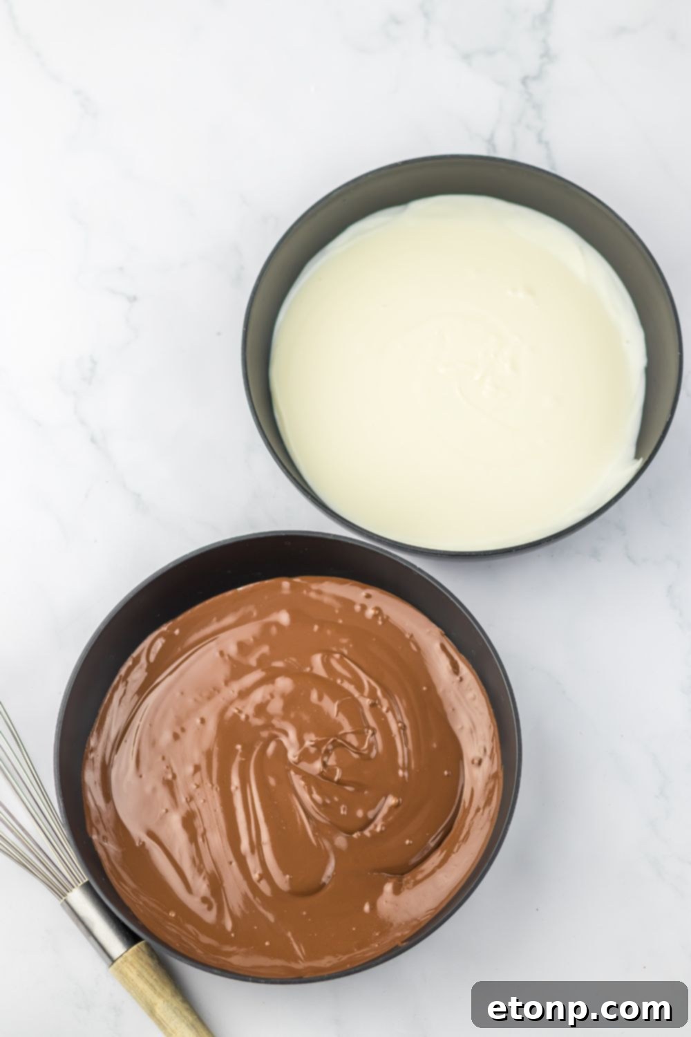 White chocolate and milk chocolate melted in bowls on table