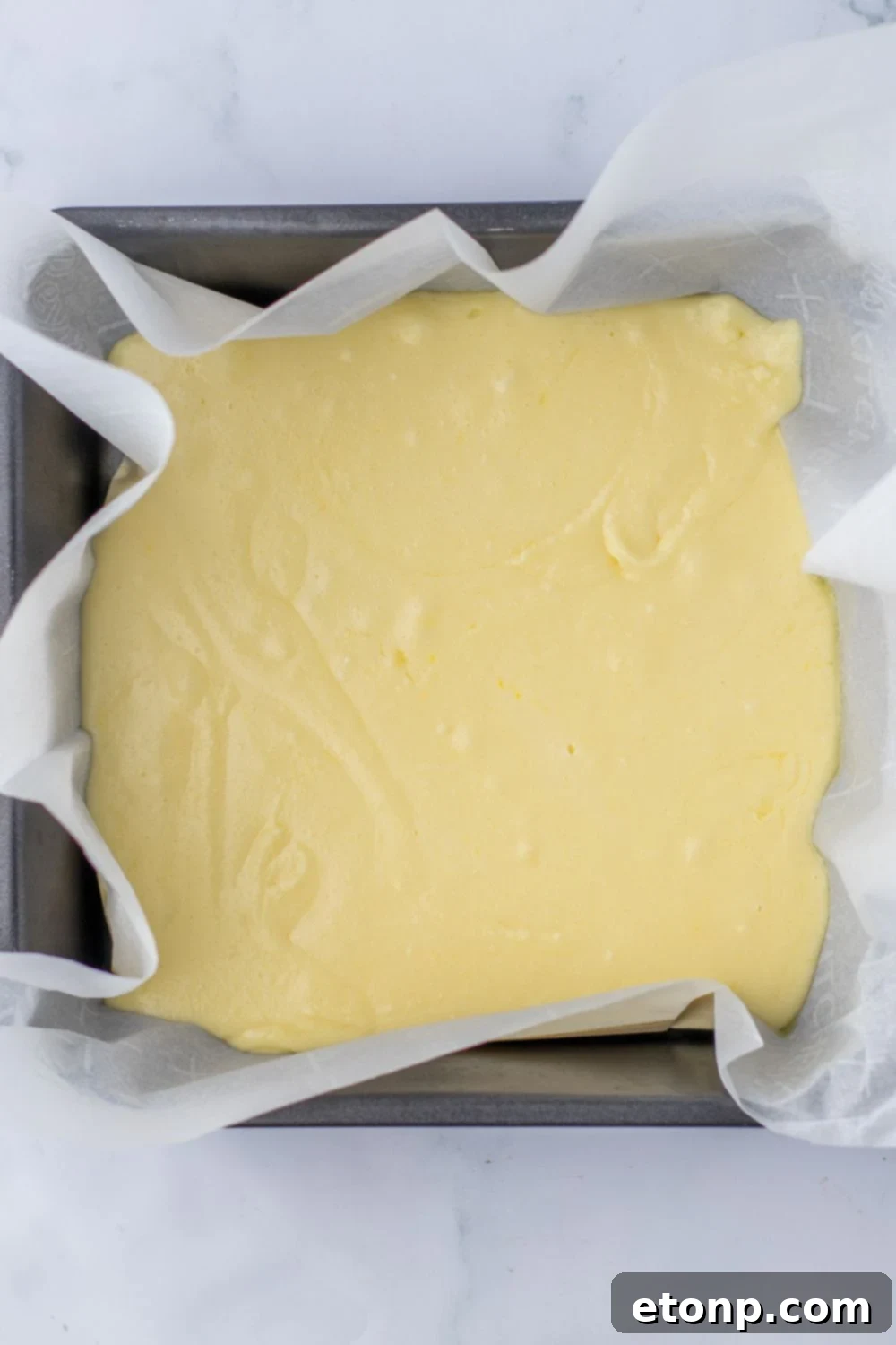vanilla fudge in a pan with parchment paper