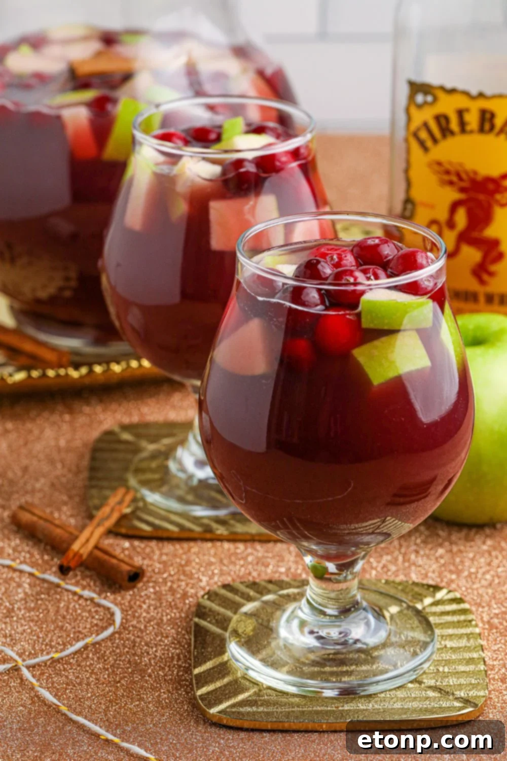 Cinnamon Spice Sangria 5 Close-up of Fireball Sangria in a glass, with visible apple slices and cranberries, ready to be enjoyed.