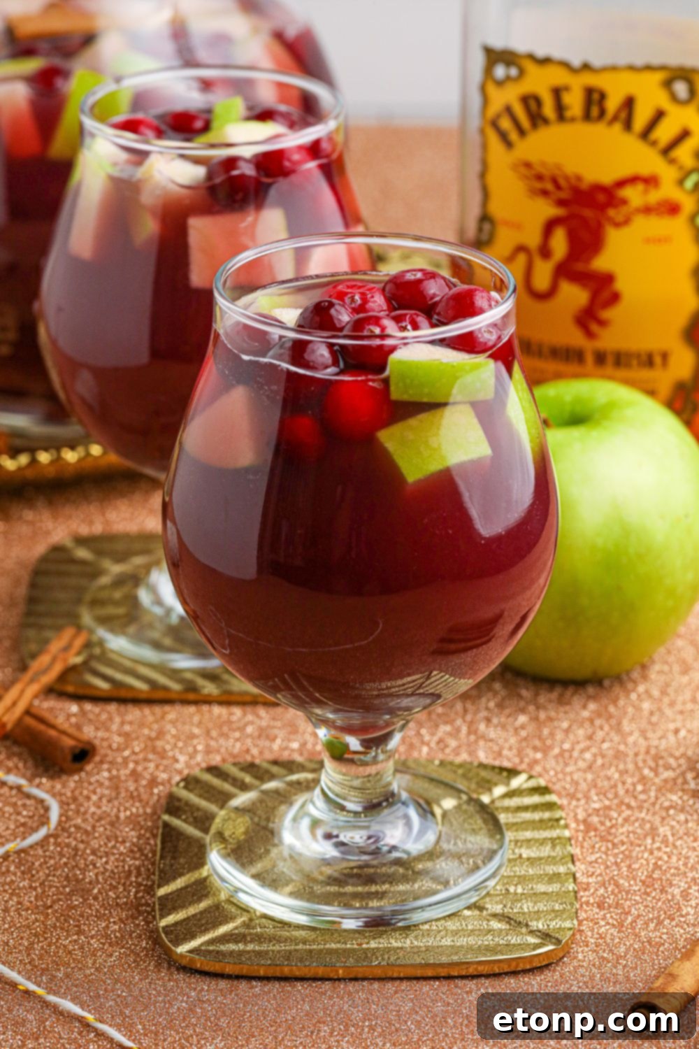 Cinnamon Spice Sangria 6 A glass of Fireball Apple Cider Sangria, garnished with apple slices and a cinnamon stick, capturing a festive and delicious vibe.