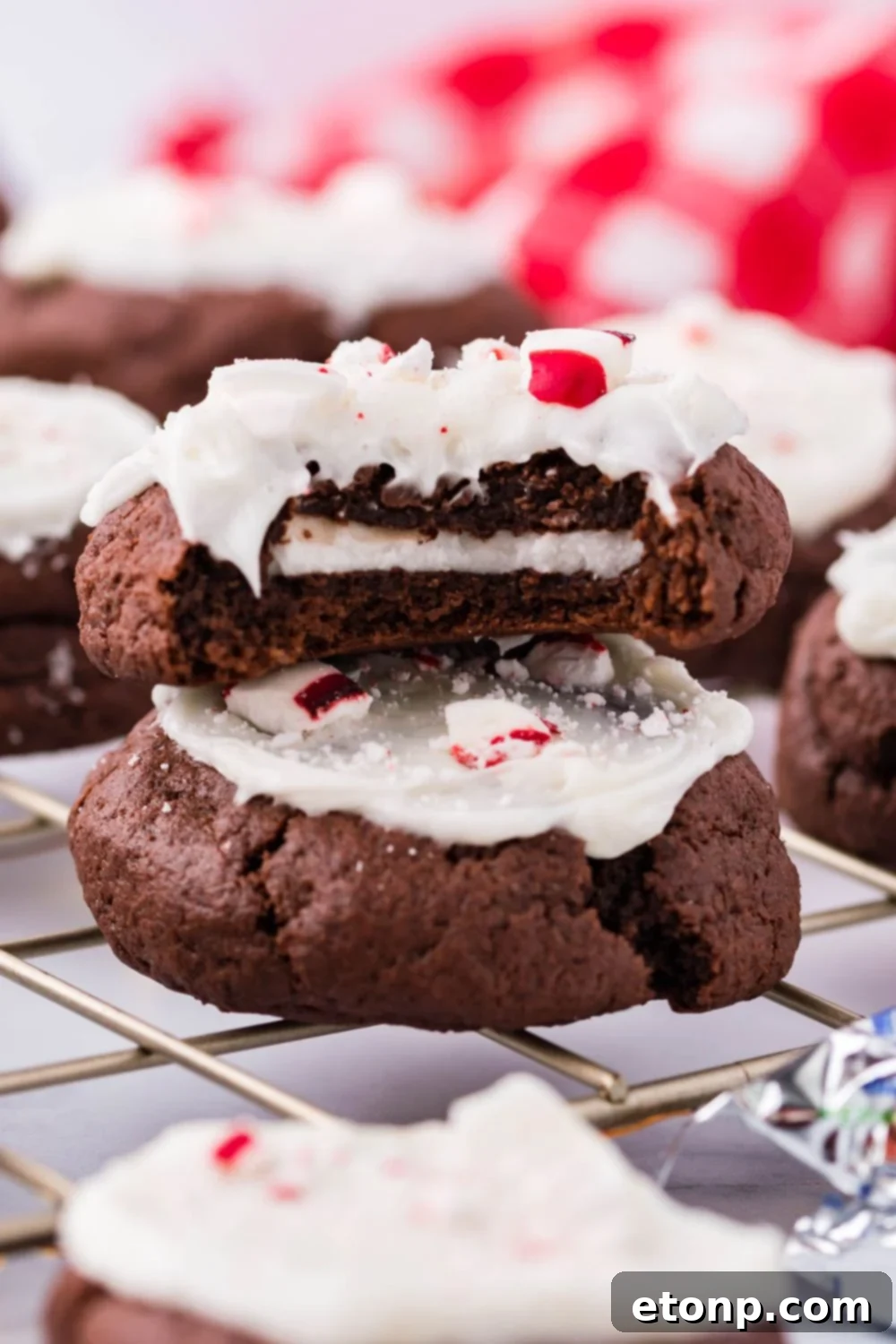 Molten Peppermint Patty Chocolate Cookies 13 Side view of chocolate peppermint cookies on a table, one with a bite taken out