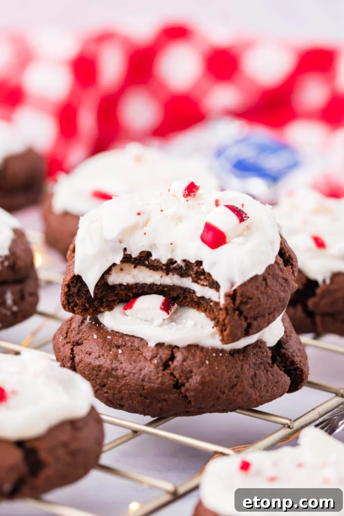 Molten Peppermint Patty Chocolate Cookies 14 Peppermint Patty Stuffed Cookies on a cooling rack, one with a bite missing