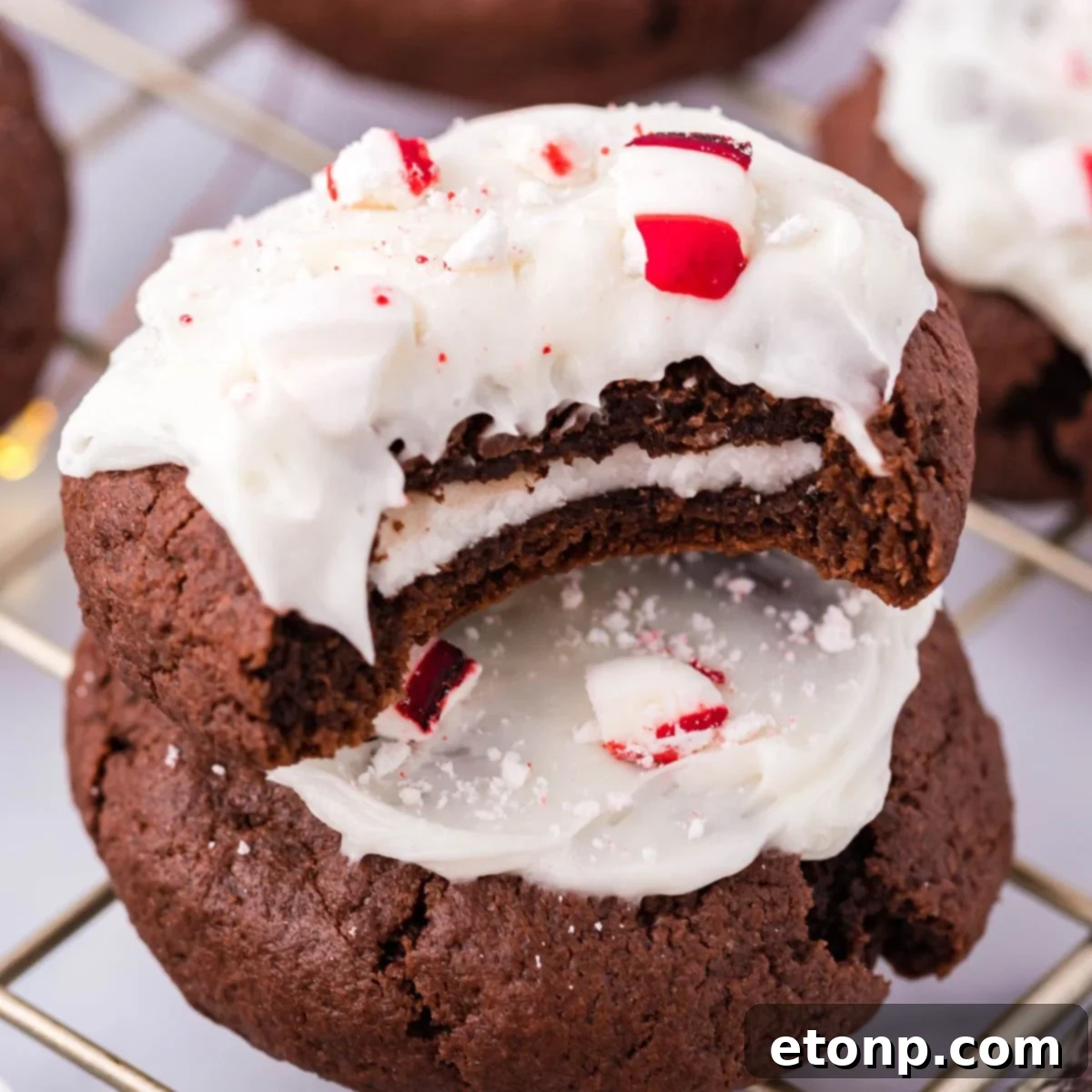 Molten Peppermint Patty Chocolate Cookies 3 Stacked Stuffed Peppermint Patty Cookies on a table, with a bite taken out of the top cookie revealing the mint filling