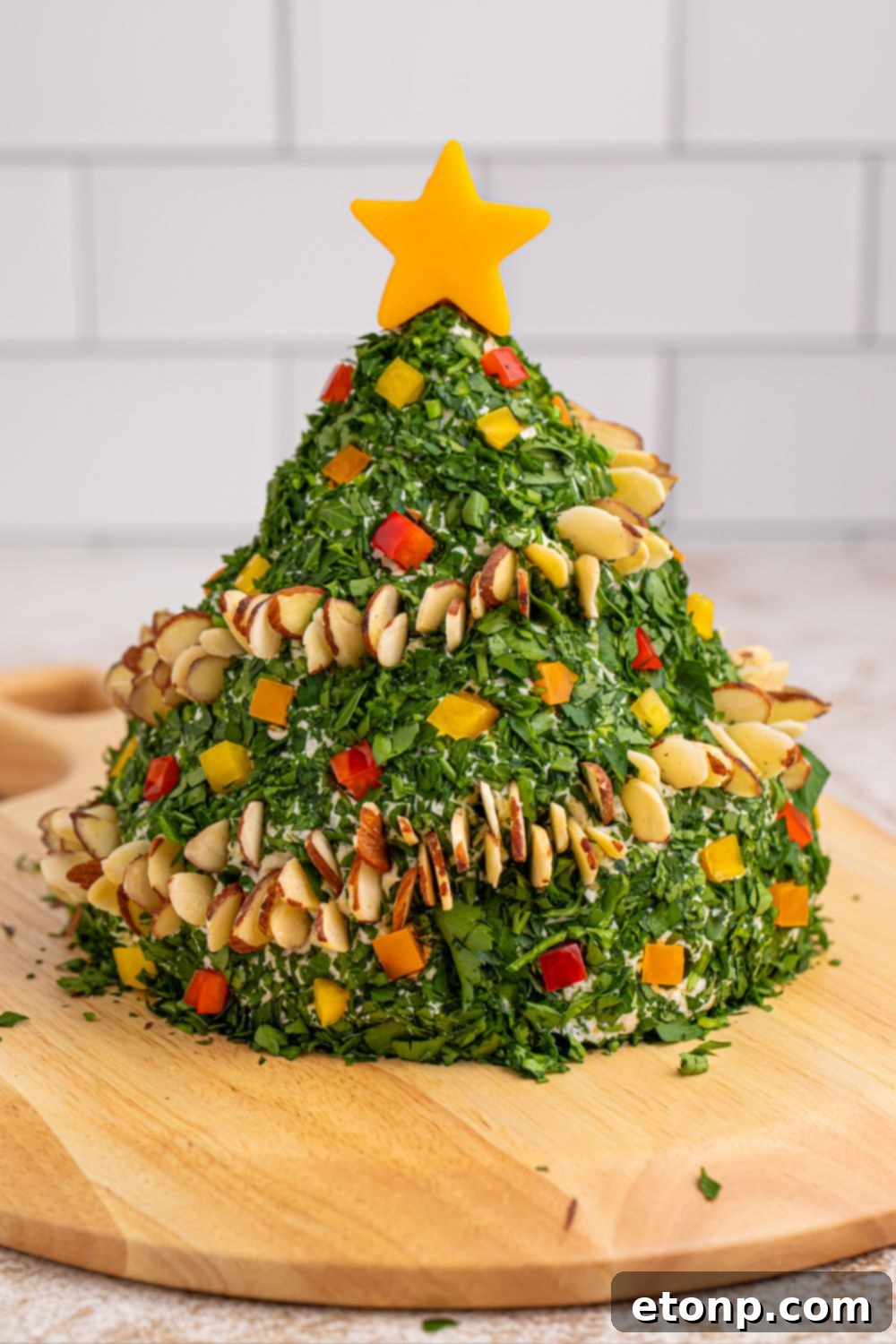 Christmas Tree Cheeseball on a wooden cutting board with a knife