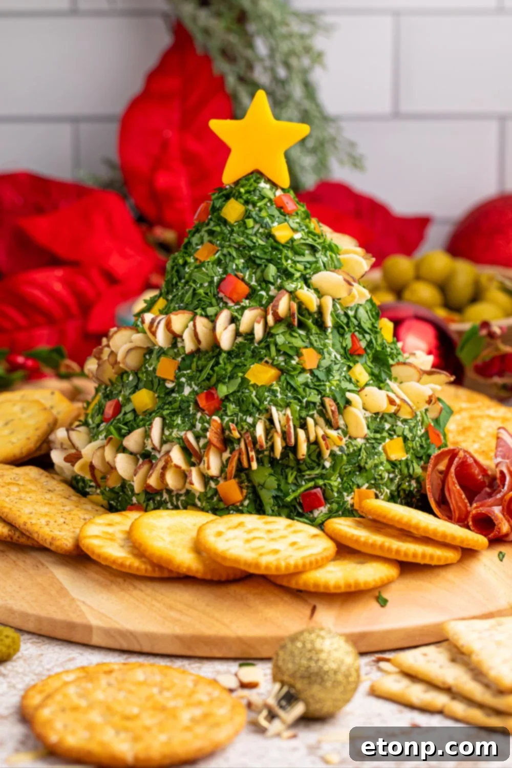 Christmas Tree Cheeseball on a table with various ingredients surrounding it