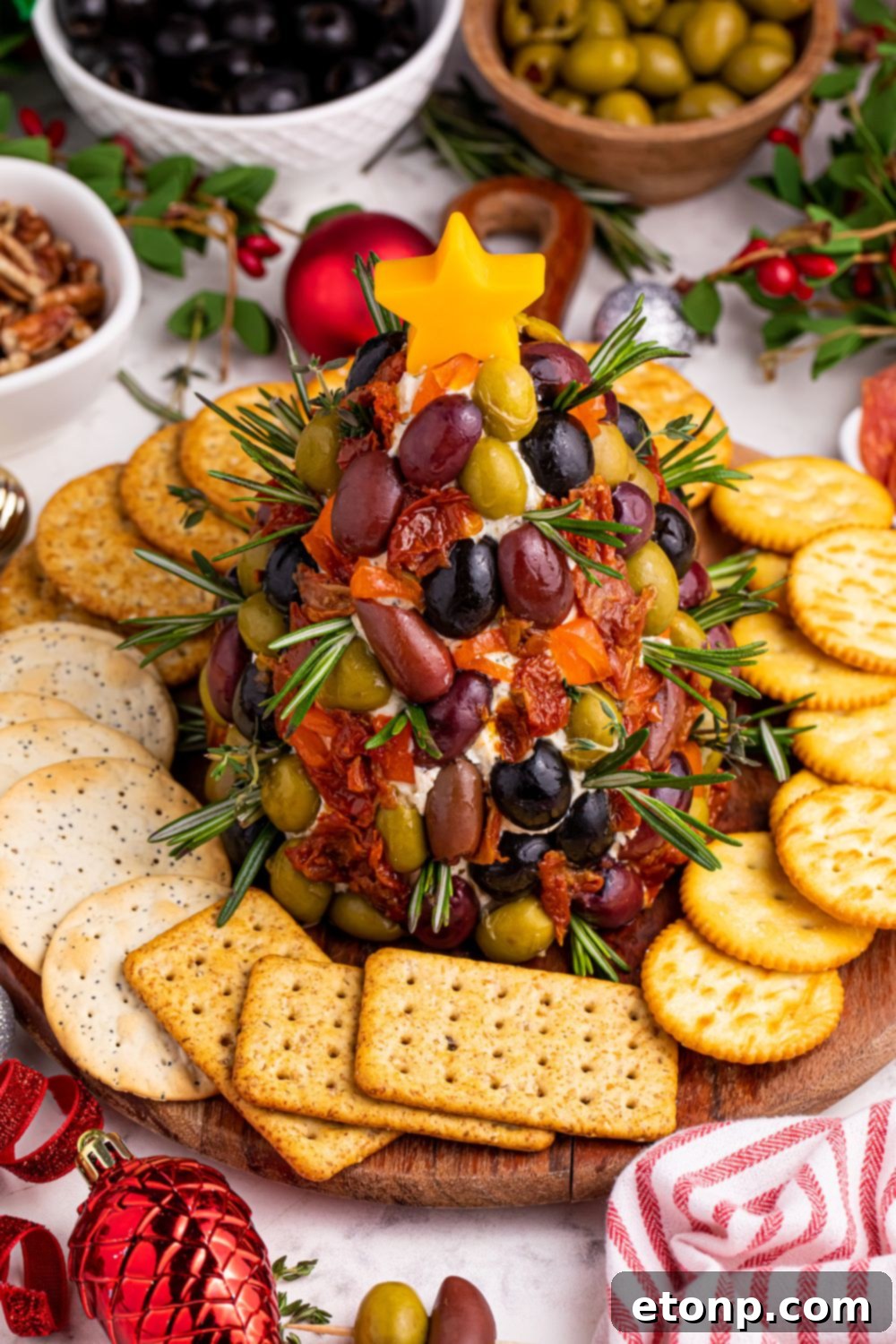 A festive Christmas appetizer platter, featuring the cheeseball surrounded by an elegant arrangement of crackers and other dipping options.