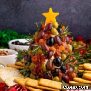 Antipasto Christmas Tree cheese ball on table with crackers around it
