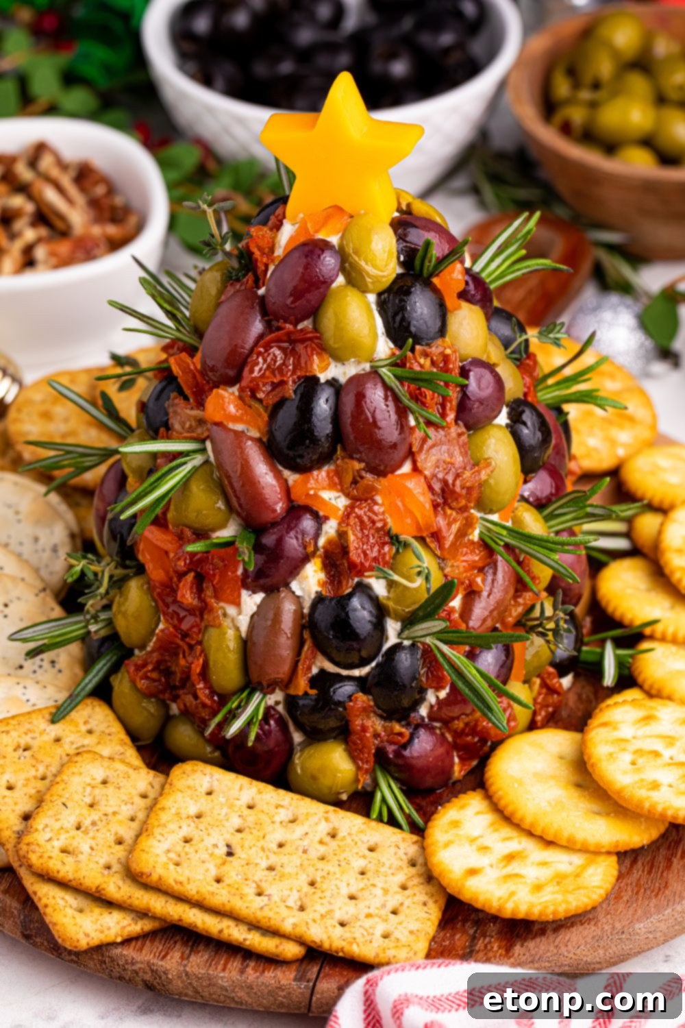 The complete holiday cheeseball appetizer, elegantly arranged on a platter with an assortment of crackers and nuts, ready to serve.