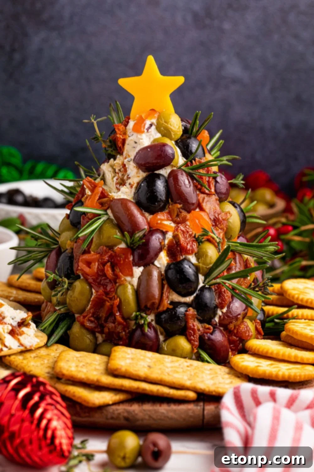 A festive cheeseball centerpiece, adorned with a bright star and surrounded by an assortment of crackers, perfect for a holiday table.