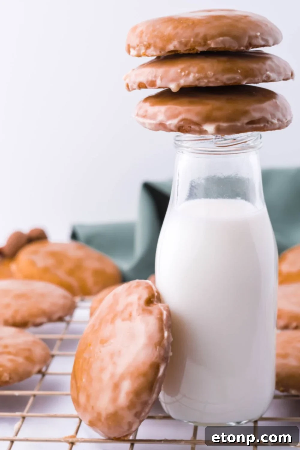 Glass milk bottle with cookies arranged on top and beside it