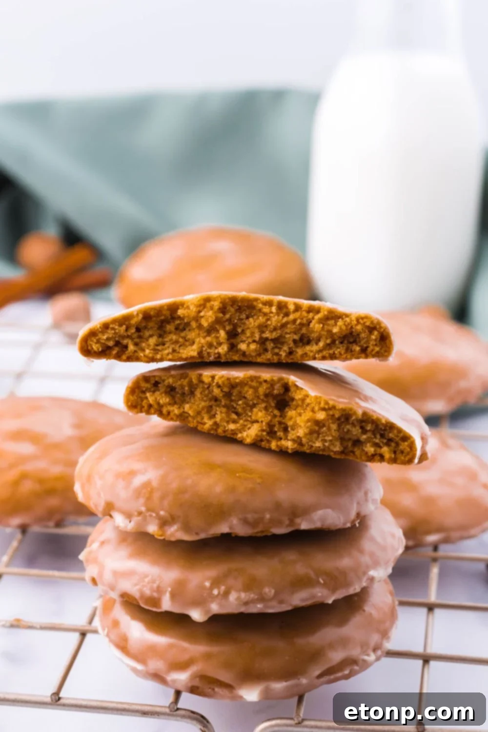 Cookies stacked on top of each other with one bitten in half, highlighting the fresh glaze