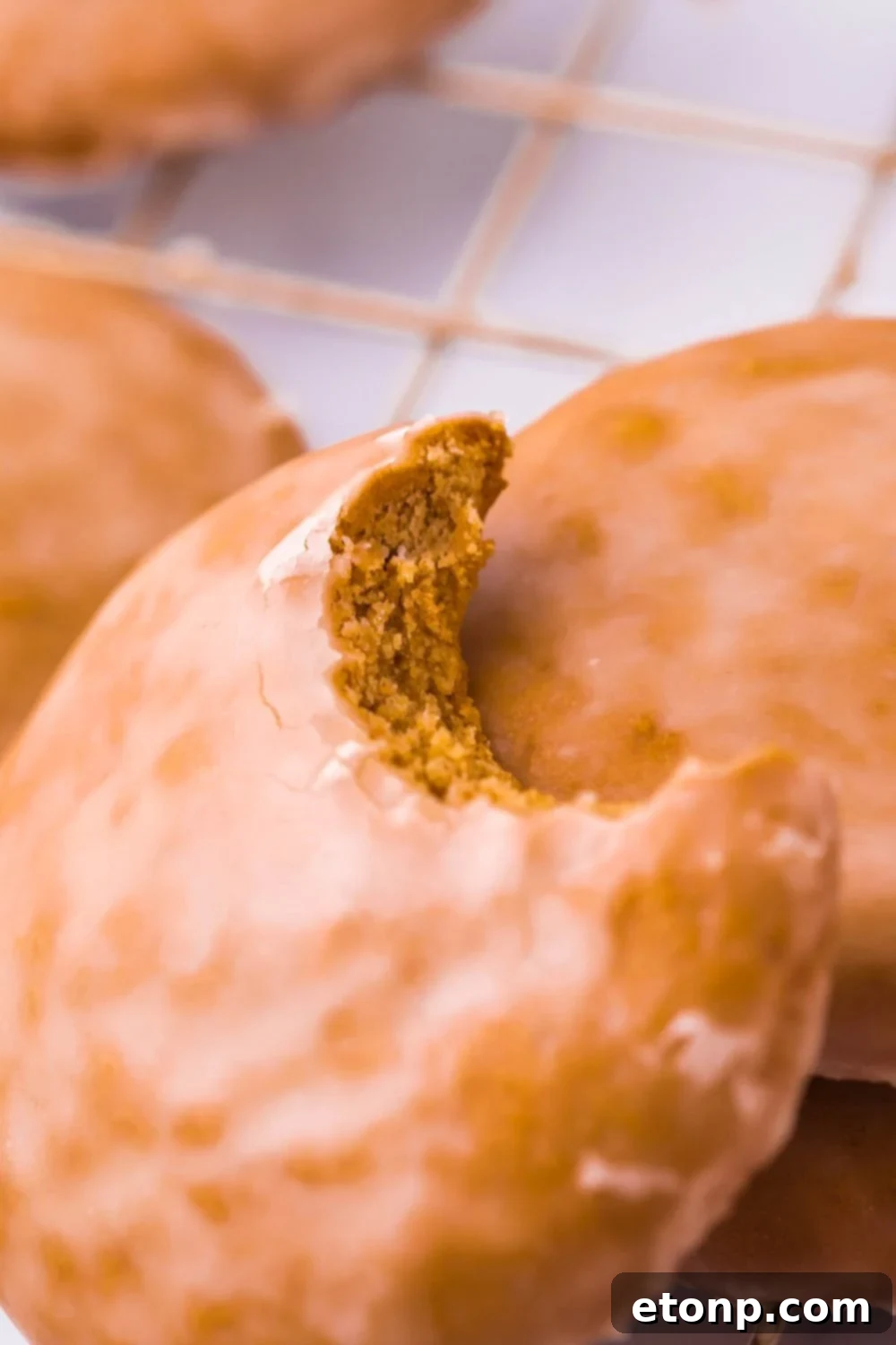 Lebkuchen Gingerbread Cookies on a cooling rack with a bite taken out of one, showing the light glaze