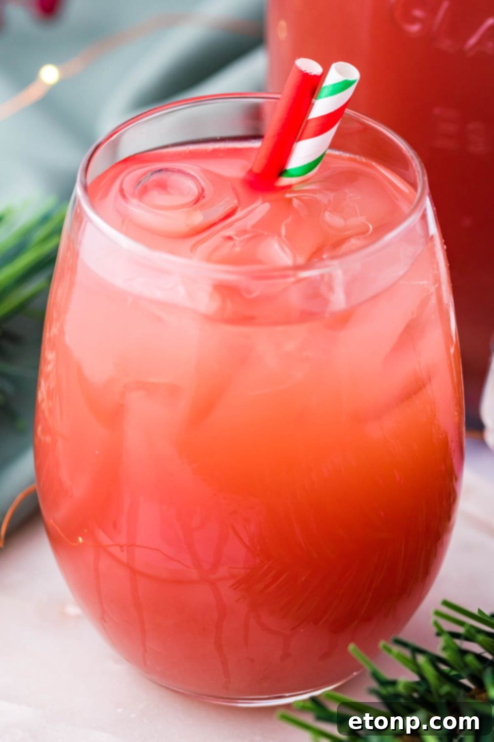 holiday cranberry punch in a glass with two straws