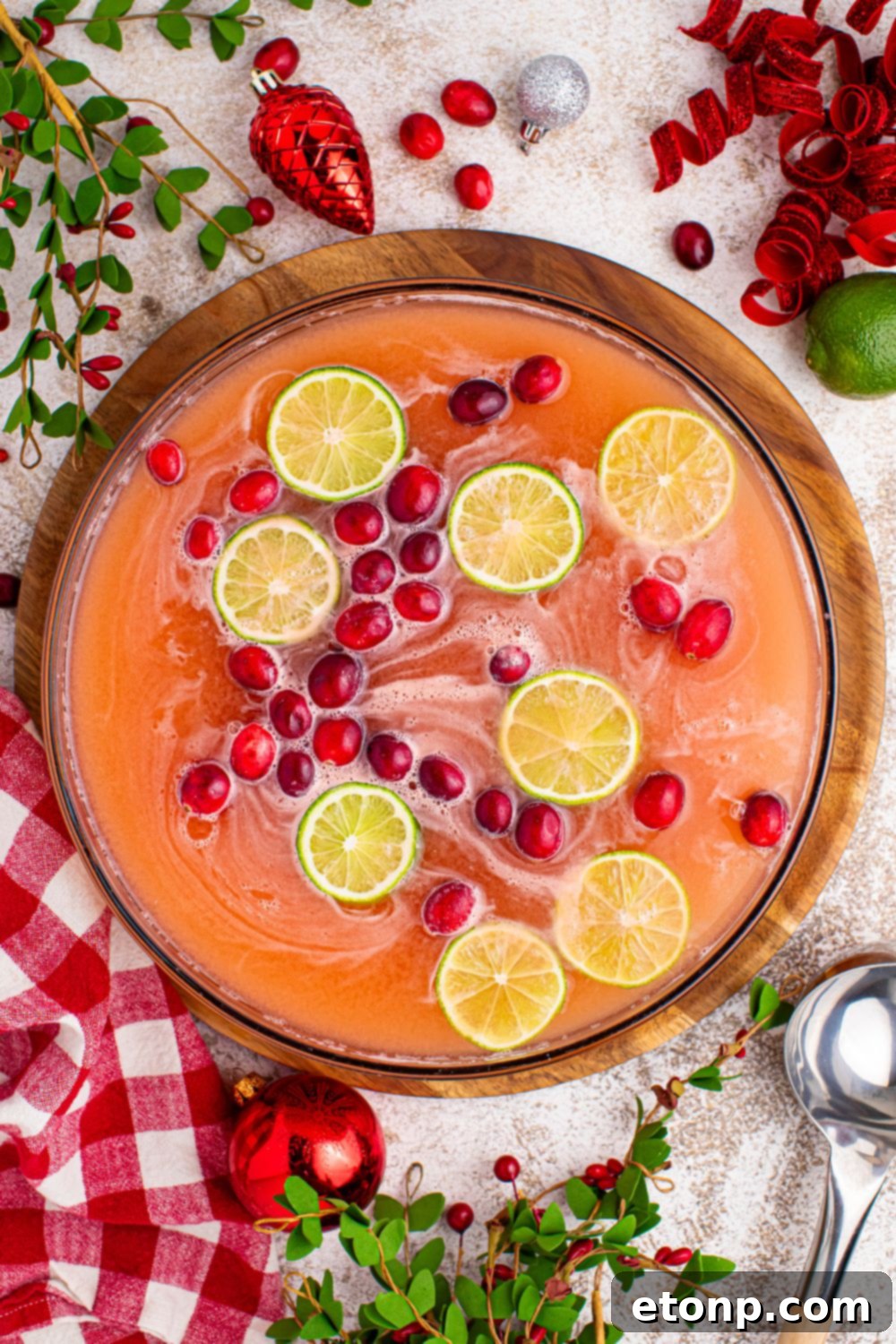 A festive holiday punch, beautifully presented in a clear glass bowl, showcasing its rich red color and inviting frothy top, ready to be served to guests.