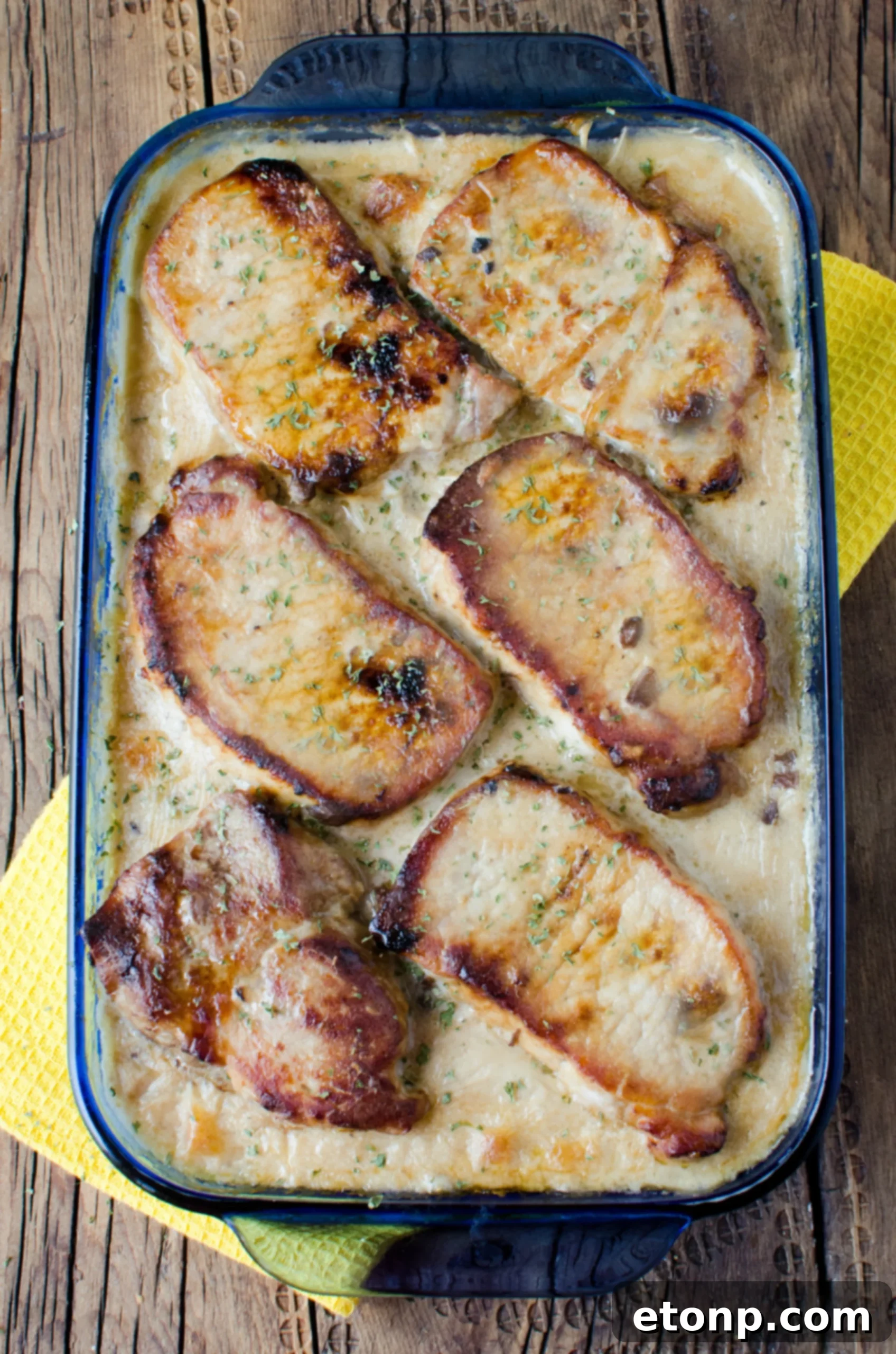 Smothered Pork Chops and Scalloped Potatoes Casserole 13 Overhead shot of the finished casserole dish, garnished with fresh parsley.