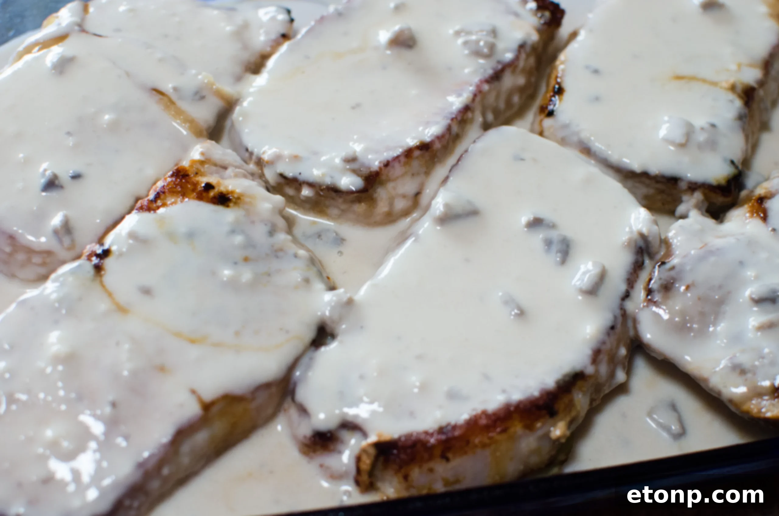 Smothered Pork Chops and Scalloped Potatoes Casserole 6 Thinly sliced potatoes layered neatly in a baking dish, preparing for the pork chops and sauce.