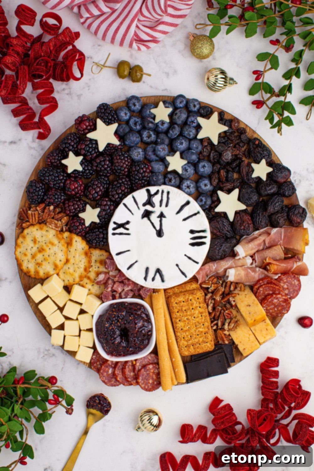 New Year's Eve Charcuterie Board on table with an overhead look with nuts, cheese, berries and more on the serving tray 