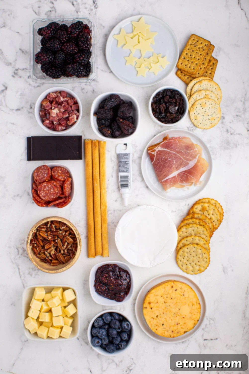 New Year's Eve Charcuterie Board ingredients placed on the table in glass bowls to showcase each item for the charcuterie snacking board 
