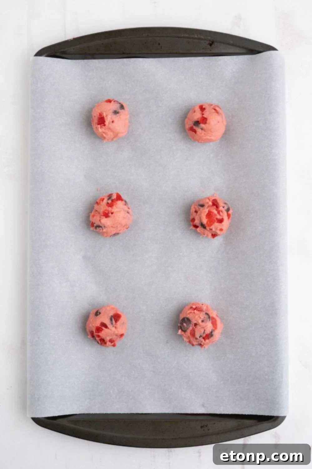 Cherry Chocolate Chip Cookie dough balls on a parchment lined pan 