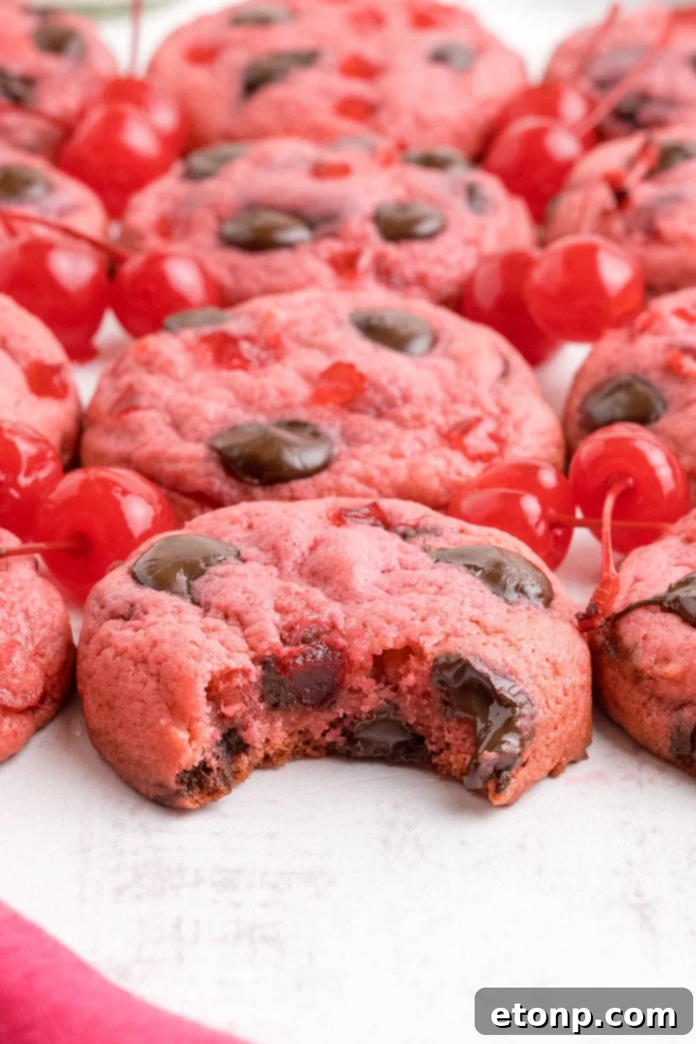 Cherry Chocolate Chip Cookies placed on the table and a bite taken out of one of the cookies 