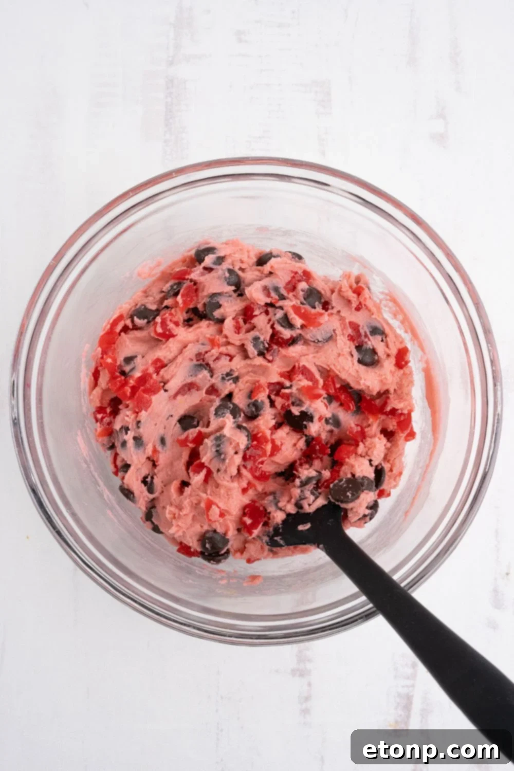 Cherry Chocolate Chip Cookie dough in a bowl with a spoon on the side 