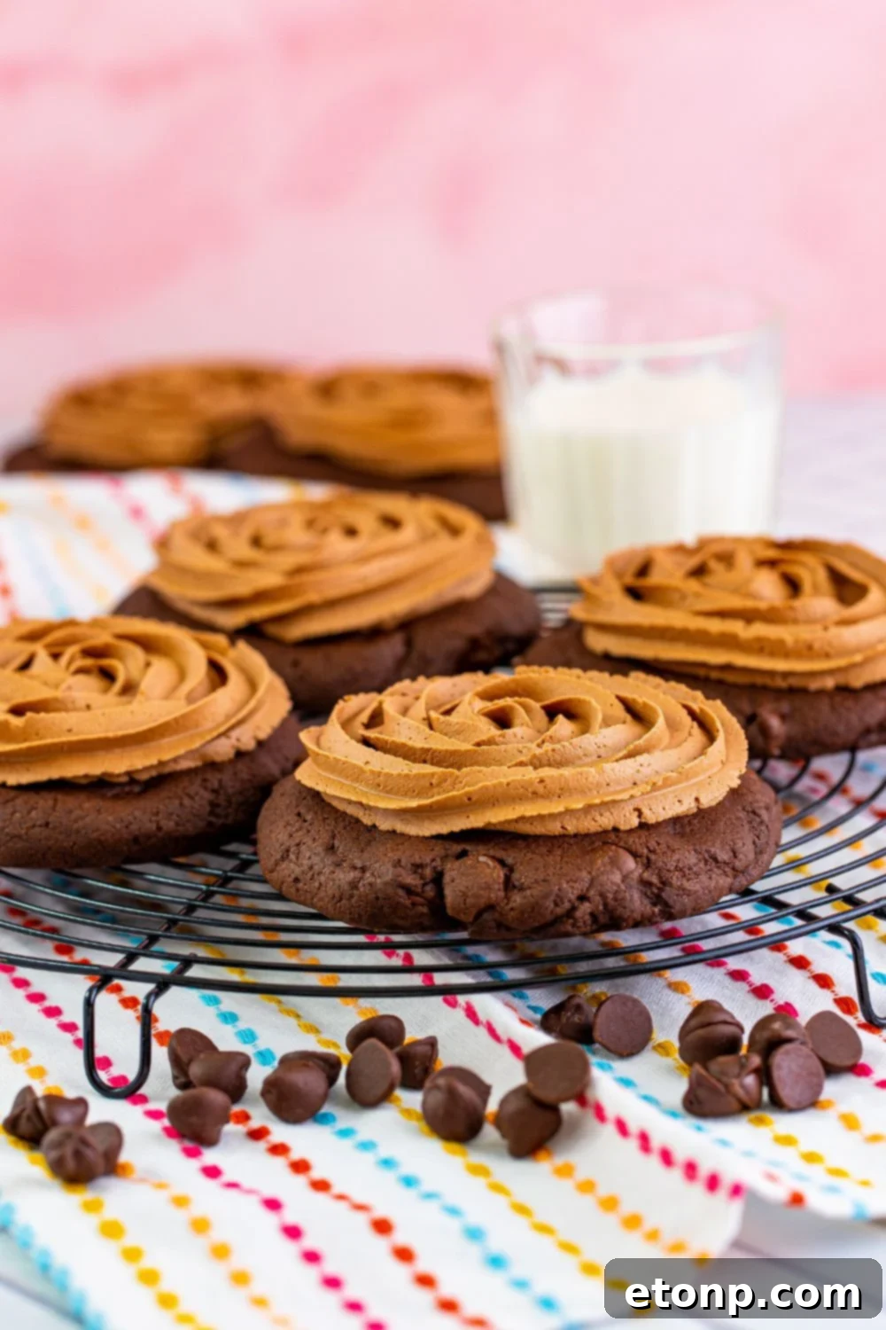 Decadent Chocolate Cake Cookies 14 Chocolate cake cookies with frosting arranged on a serving tray, with a glass of milk in the background, inviting a delicious treat.