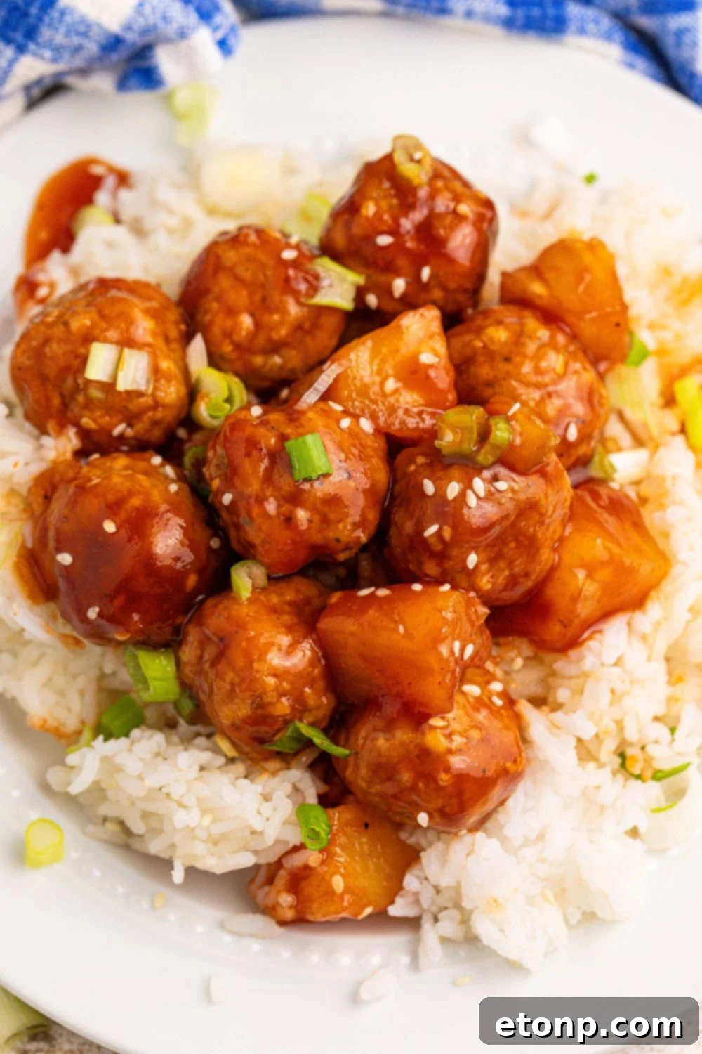 Slow Cooker 3 Ingredient Hawaiian Meatballs on plate with a bit of white rice under the meatballs 